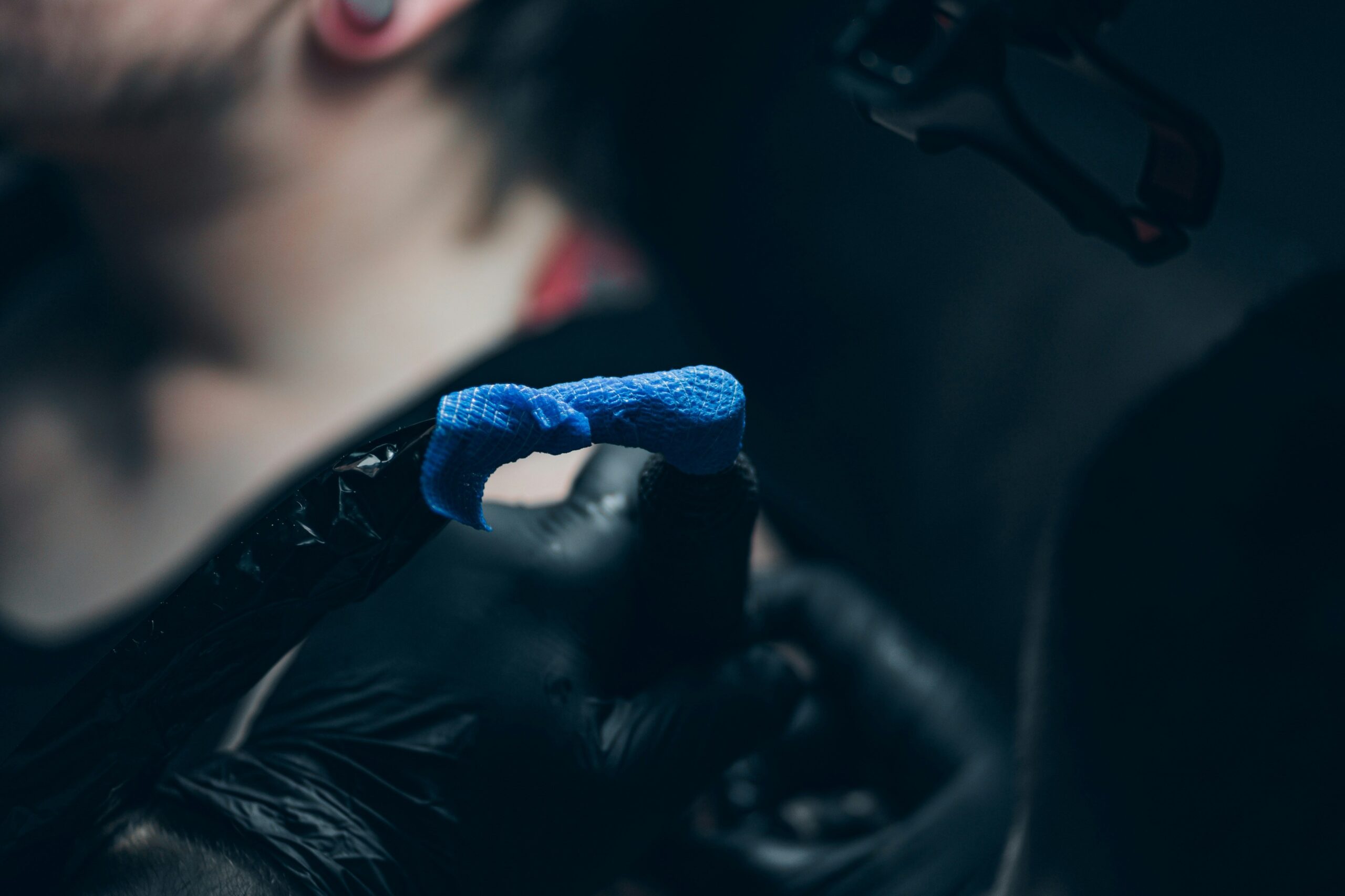 A biomechanical arm tattoo featuring intricate gears and glowing blue circuitry