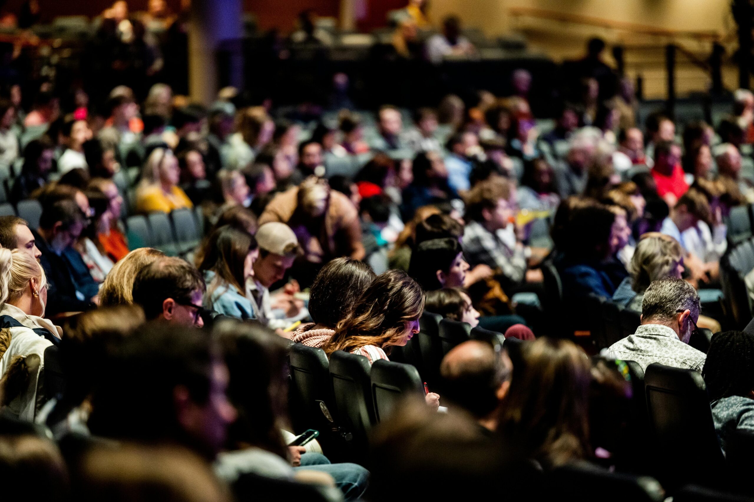 A bustling convention hall filled with attendees wearing cosplay costumes and gaming merch
