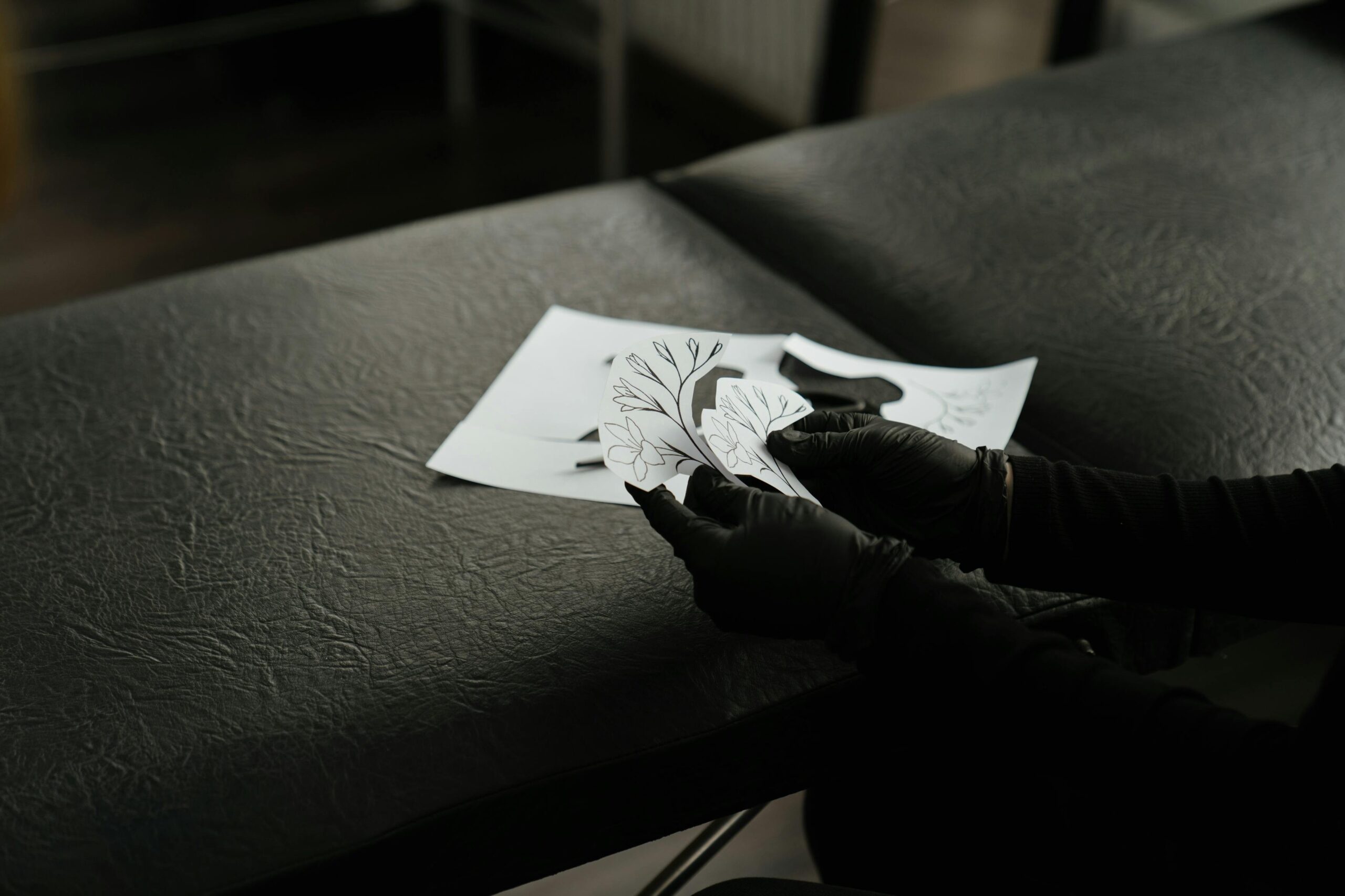 Stages of creating a tattoo design, showing sketches and finalized artwork