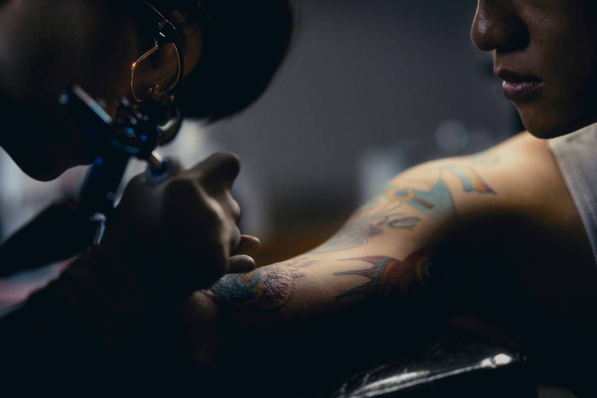 A vibrant Skyrim-themed sleeve tattoo glowing under studio lights