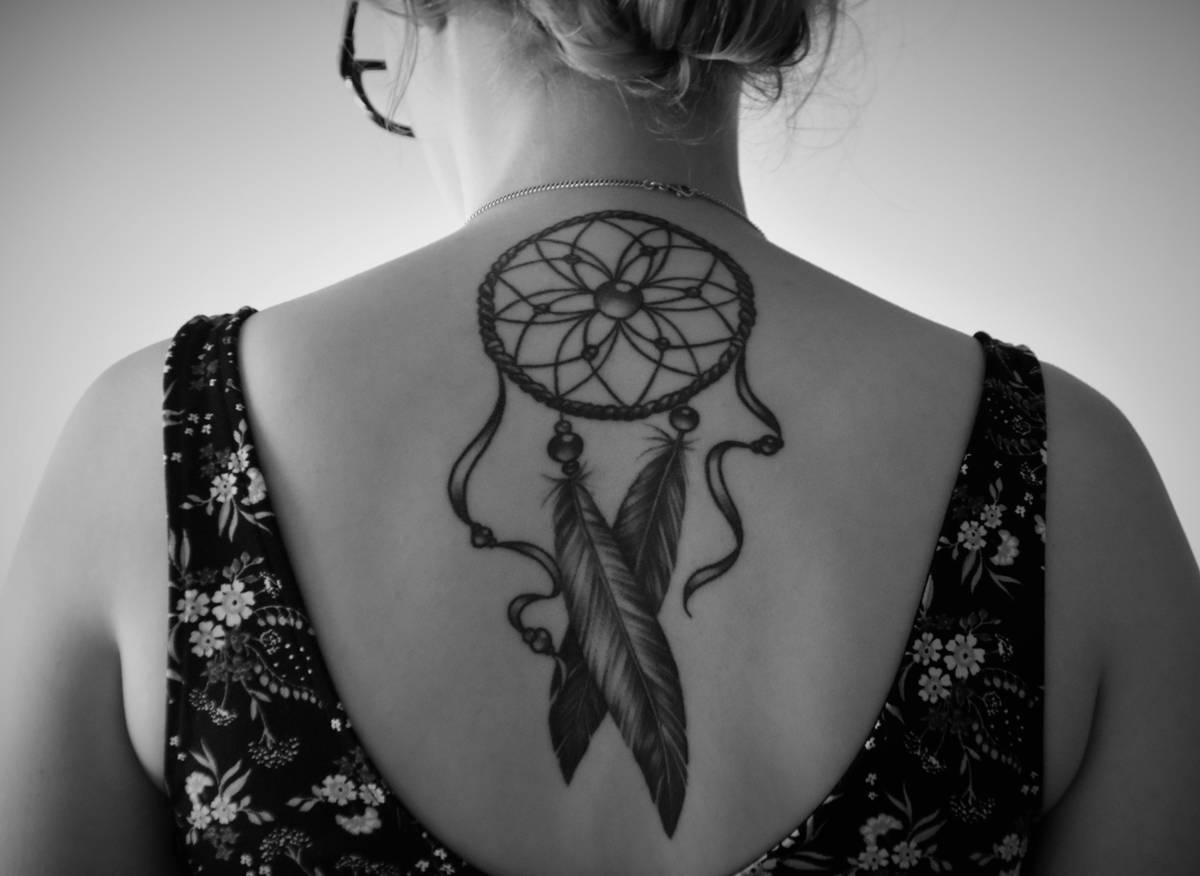 An impressive close-up shot of a woman's arm showcasing a surrealism gaming tattoo inspired by virtual reality headsets and digital effects.