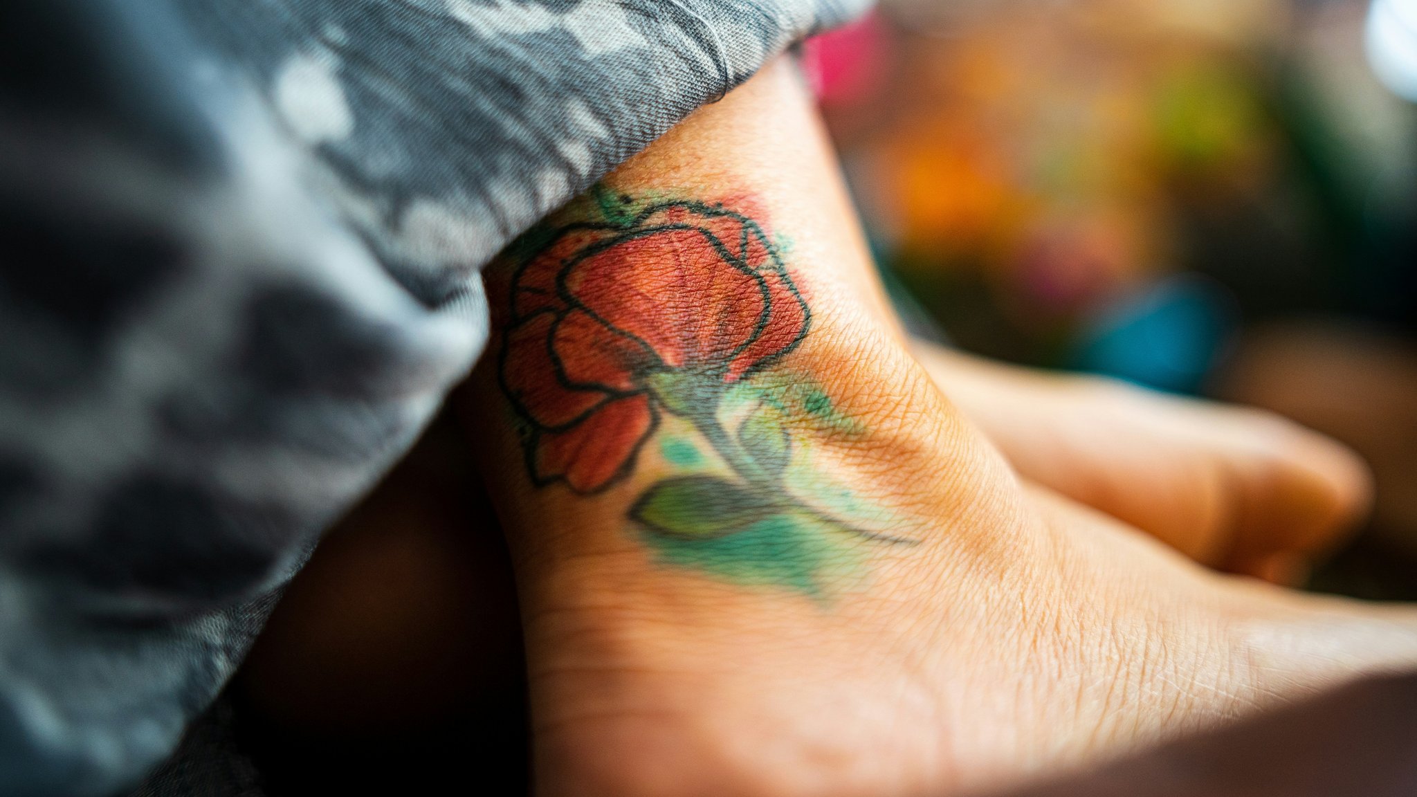 Close-up photo showing an RGB-inspired tattoo design with glowing colors