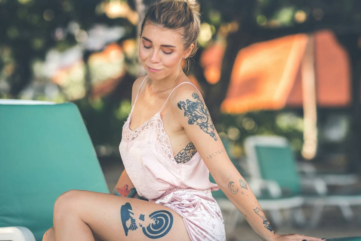 Gamer wearing protective gear to safeguard a colorful arm tattoo while playing video games at home.