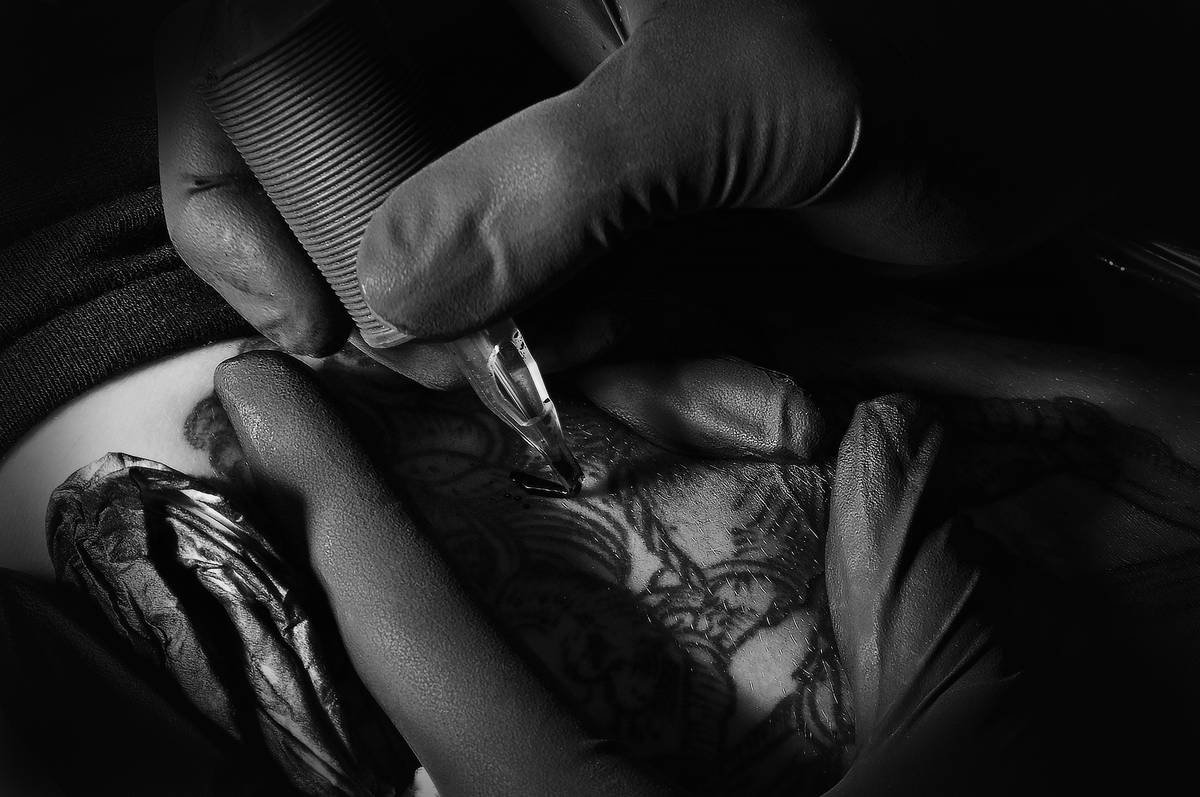 Side-by-side comparison: left shows a faded outlined gaming tattoo; right shows a sharp dotwork realism piece of the same character with depth and texture