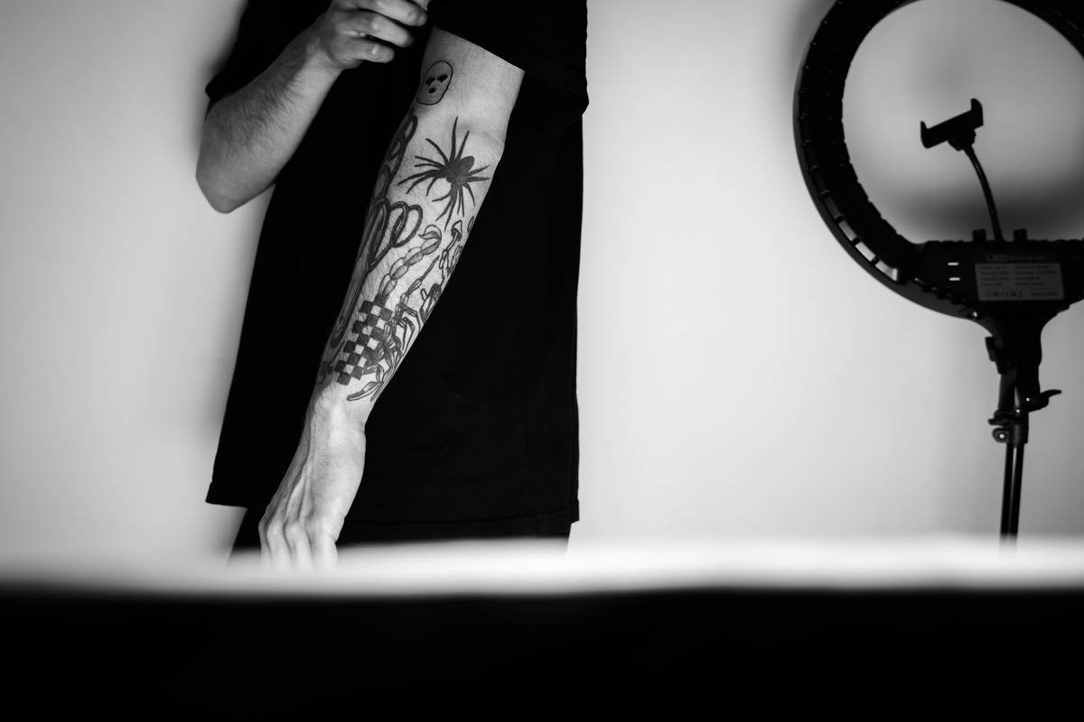 a man with a tattoo standing in front of a mirror