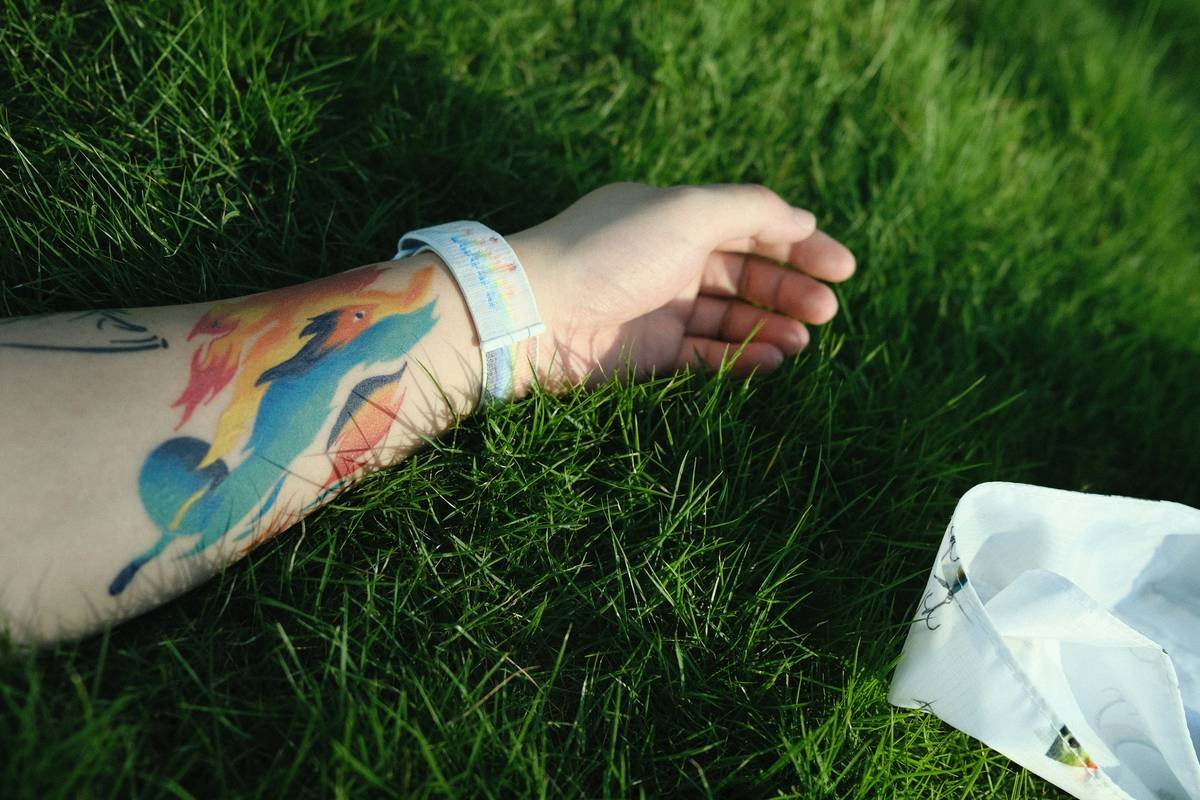 a person's hand on a blanket in the grass