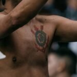 A shirtless man holding a cell phone to his ear