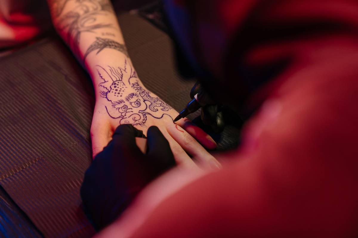 Before-and-after photos of a healed Sheikah symbol tattoo on forearm, showing clarity retention after 6 months