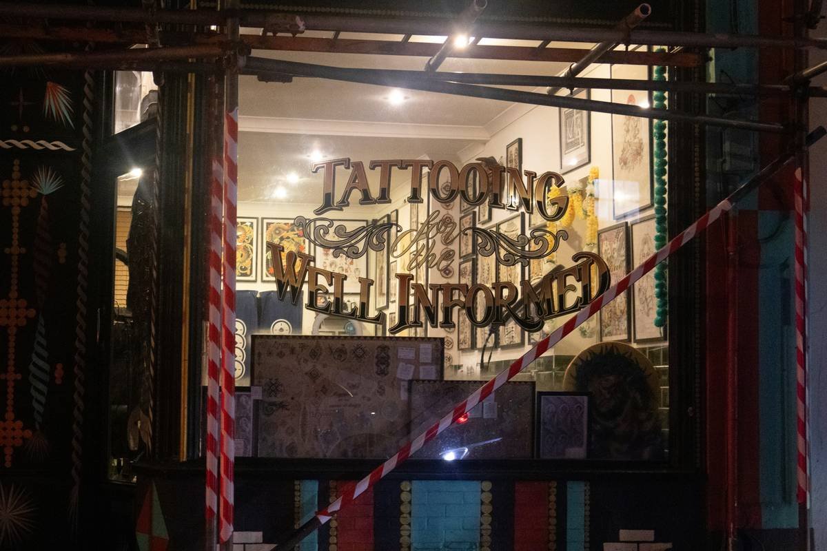 Tattoo studio window with "well informed" sign.