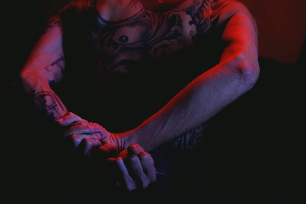 a man with a tattoo on his arm holding a pair of scissors