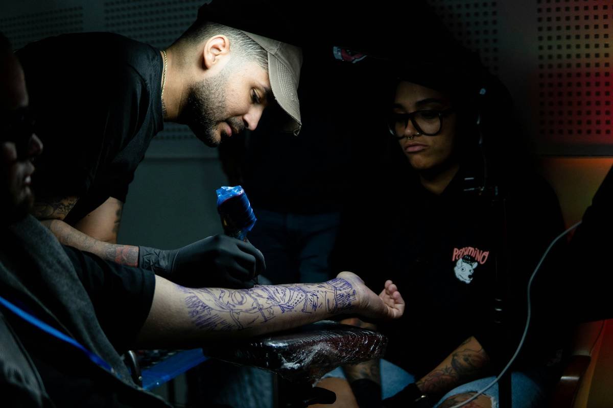 a man with tattoos on his arm and a woman with a microphone