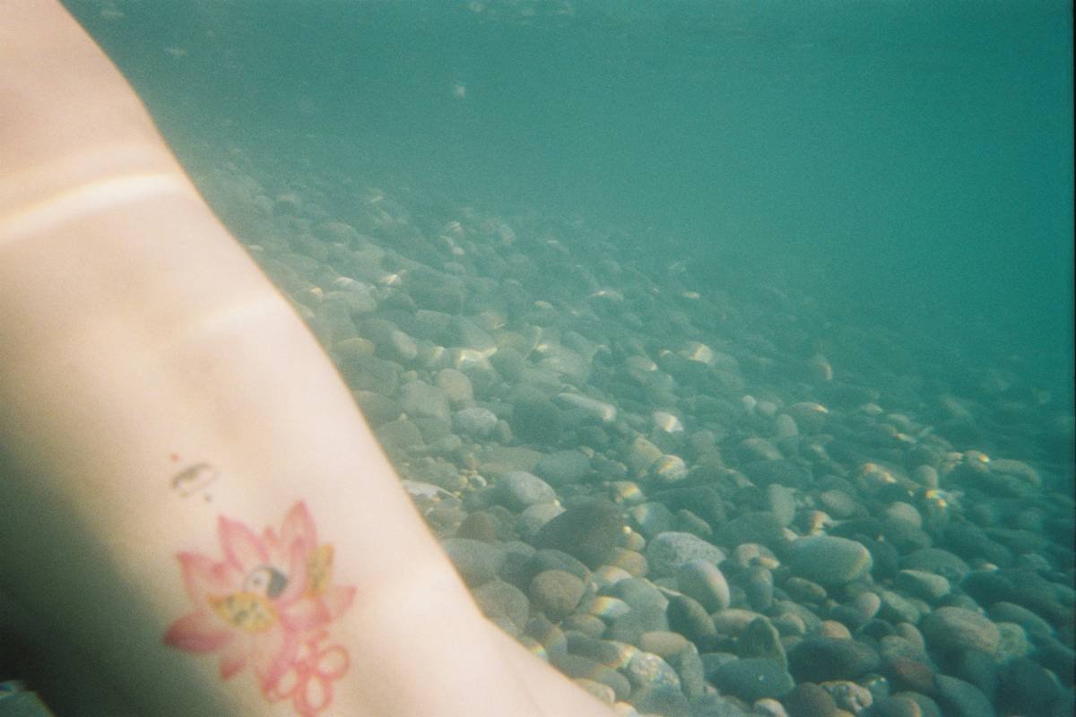 Healing tattoo ocean on forearm showing proper moisturizing technique with water-based lotion