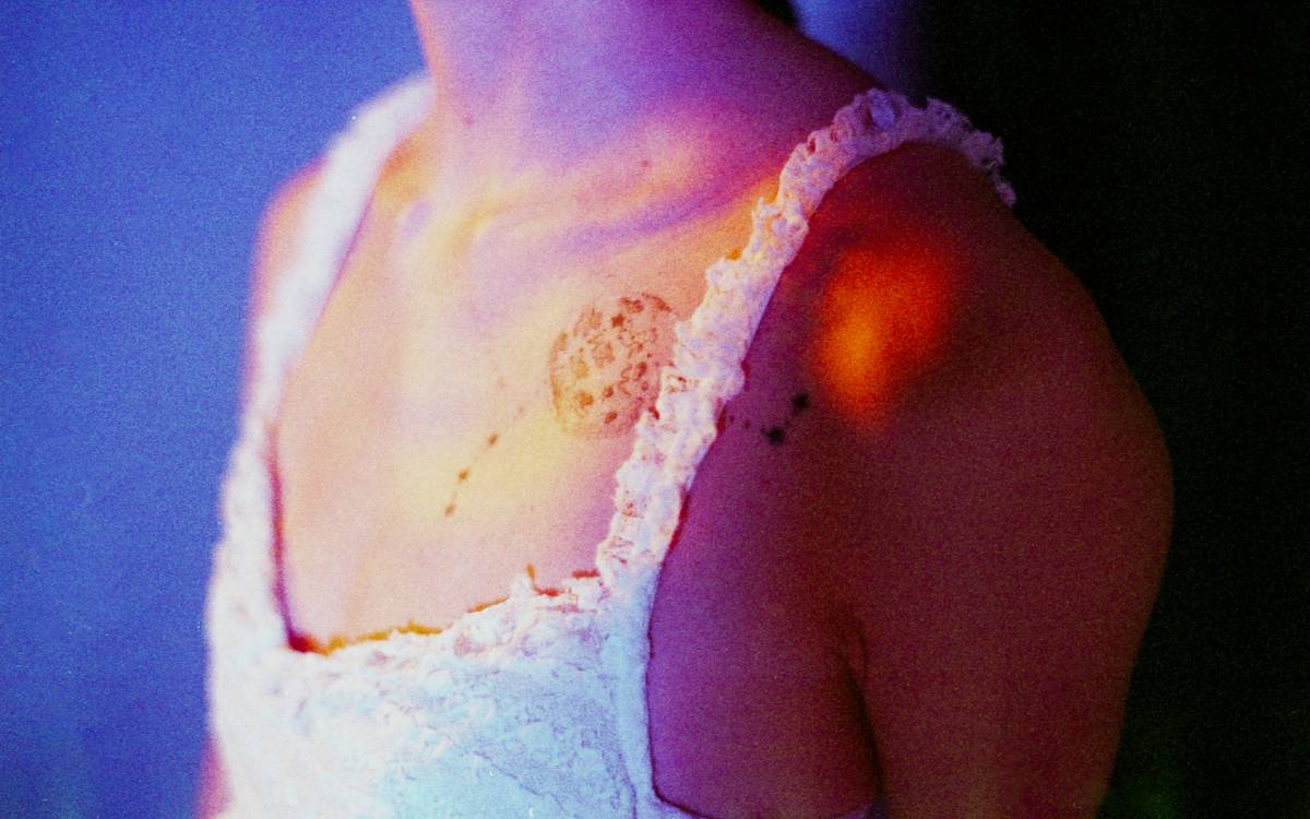 A picture of a model's tattoo above her chest taken using a film camera