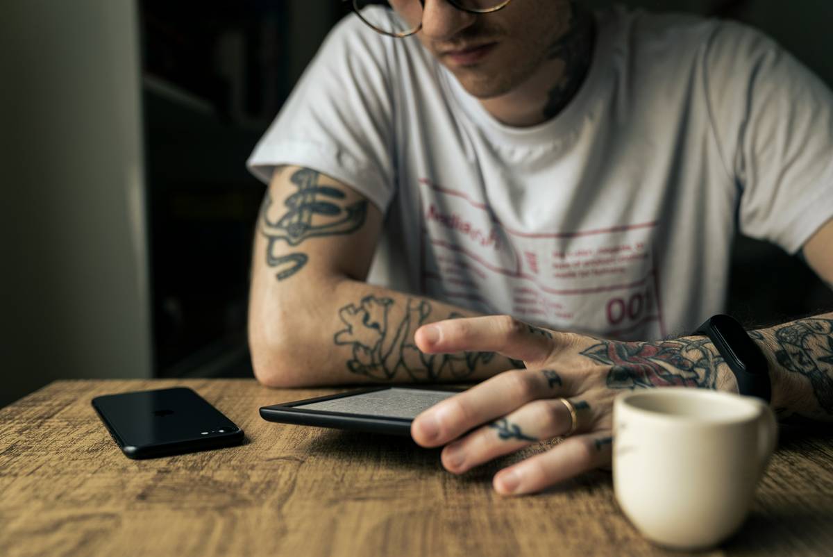 Man reading his Kindle while enjoying a coffee break.