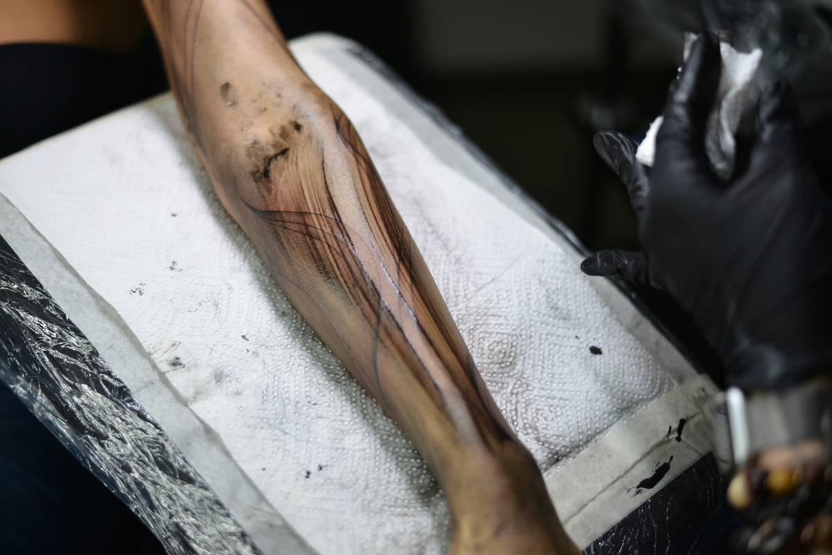 tattoo bruising visible on forearm after gaming tattoo session, showing purple-yellow discoloration around fine linework